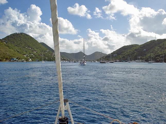 View from the bow of a sailboat looking towards shore