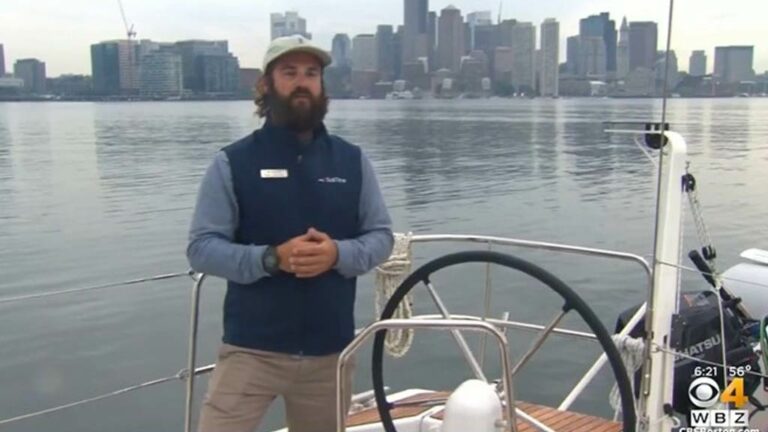 Pail Sullivan on a sailboat with the city of Boston in the background