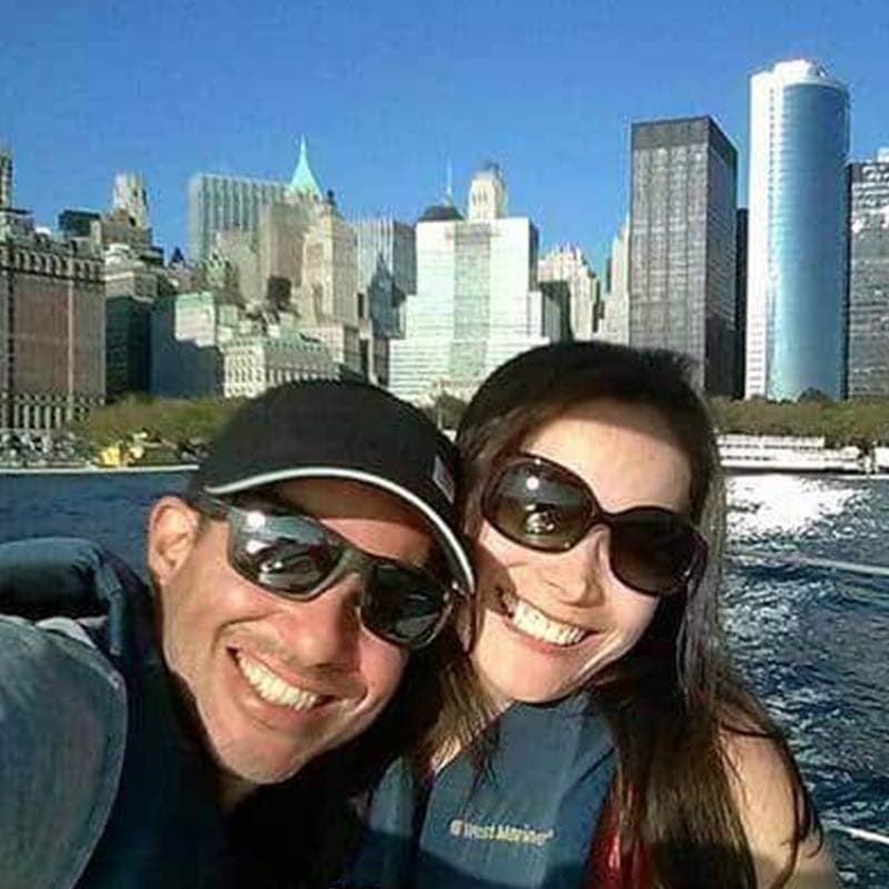 Couple posing for a photo with NYC skyline in background