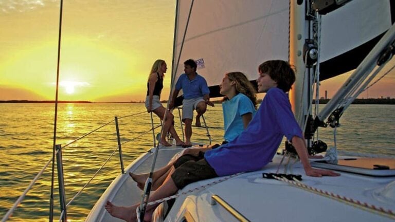 Family relaxing on a sailboat in the sunset