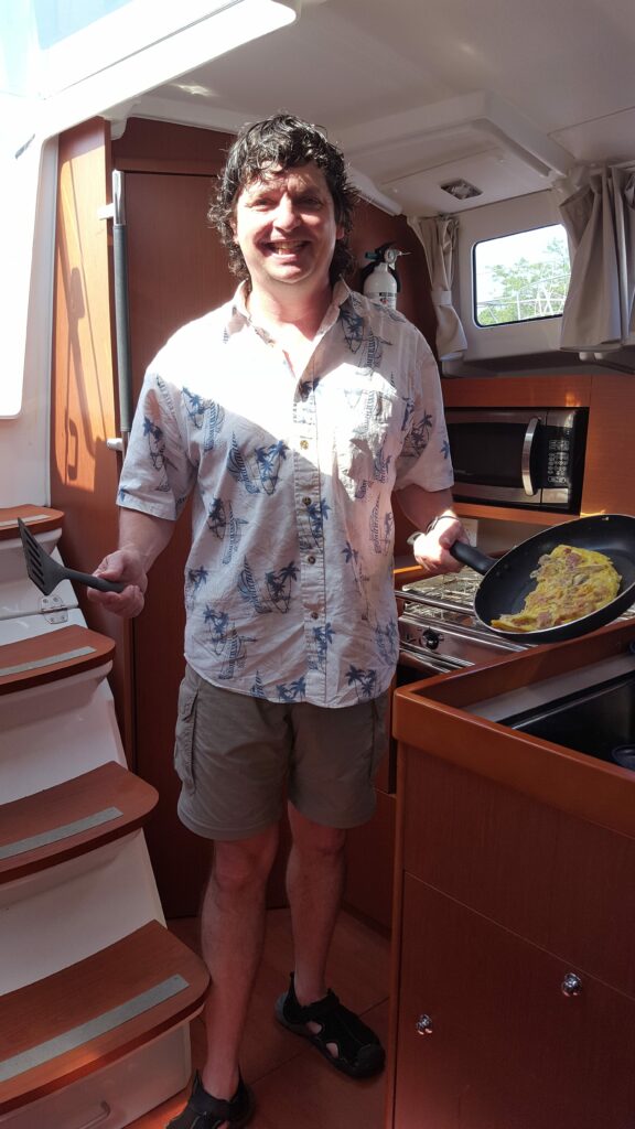 Bill posing making eggs on a sailboat
