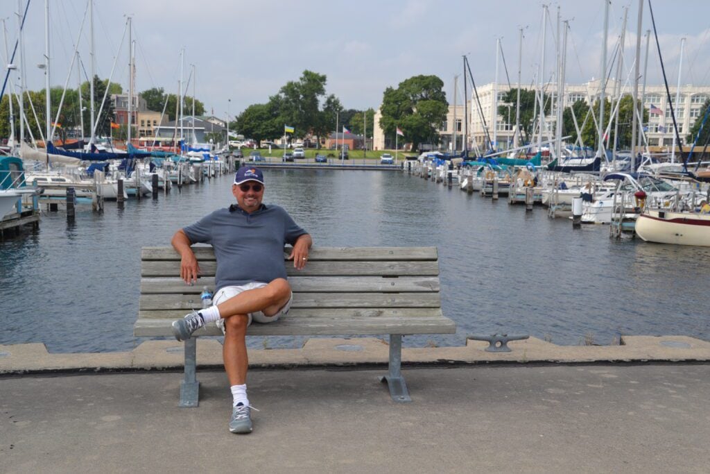 SailTime member sitting on a bench at the docks