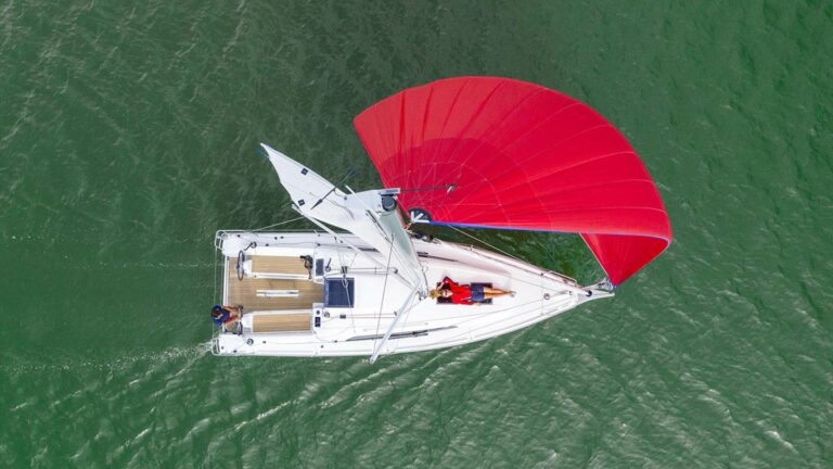 Beneteau Oceanis 30.1 from above with bright red sail blowing