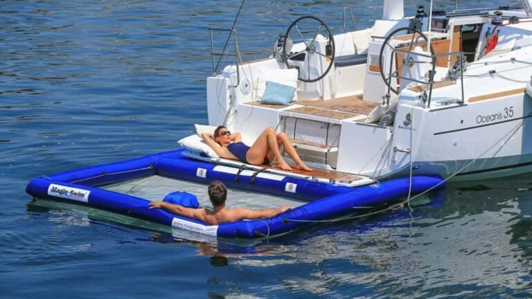 Couple relaxing in an inflatable pool off the stern of a Beneteau Oceanis 35