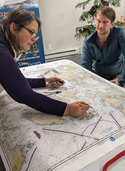 Man and woman looking over coastal navigation maps