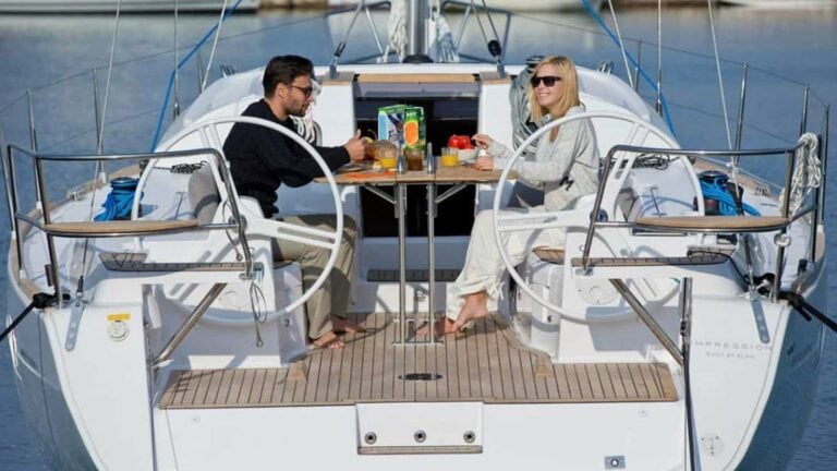 Couple eating breakfast on the deck of an Elan Impression 40