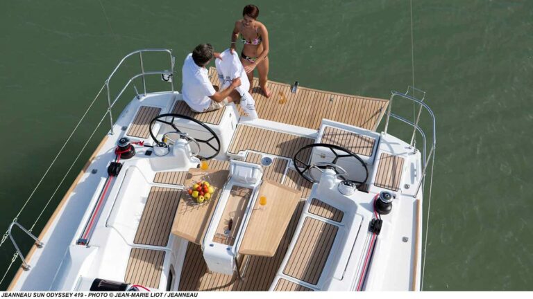Couple swimming off the stern of a Jeanneau Sun Odyssey 419