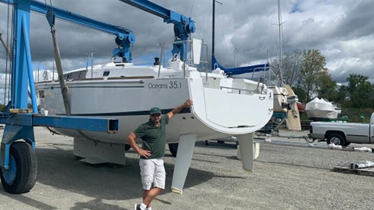 Man posing with a Beneteau Oceanis 35.1 on a trailer