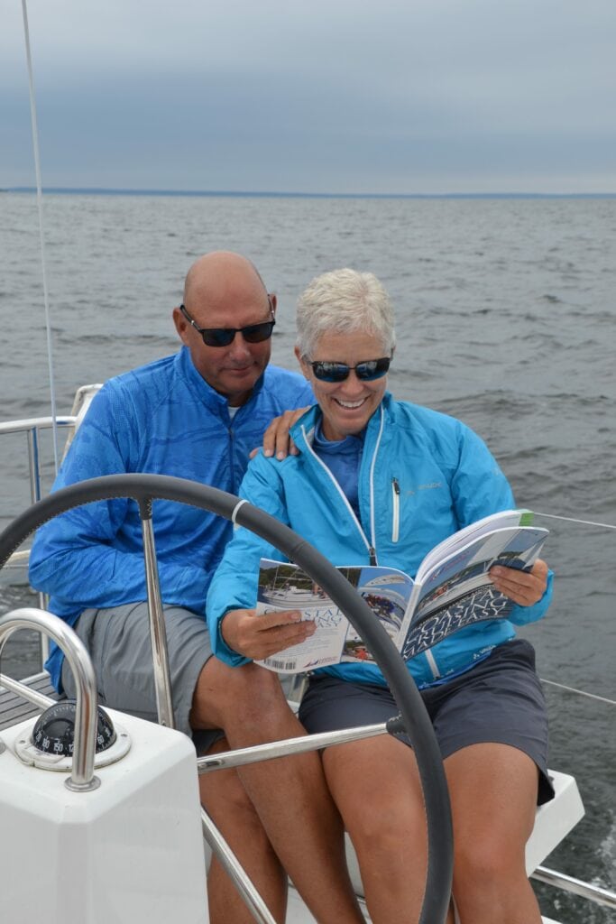 Couple reading a sailing training manual on a boat