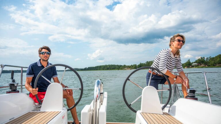 A couple at the helm of a Beneteau Oceanis 30.1.